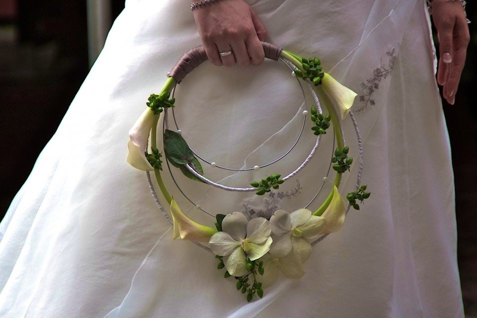 een vrouw in een trouwjurk met een bloemenboeket