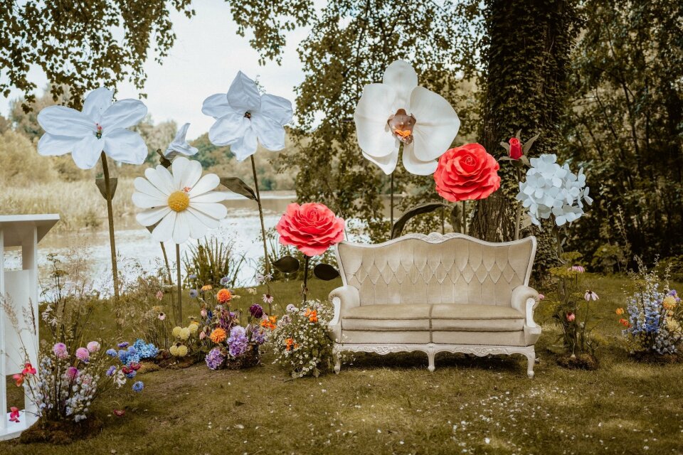 een bank in het midden van een tuin met papieren bloemen