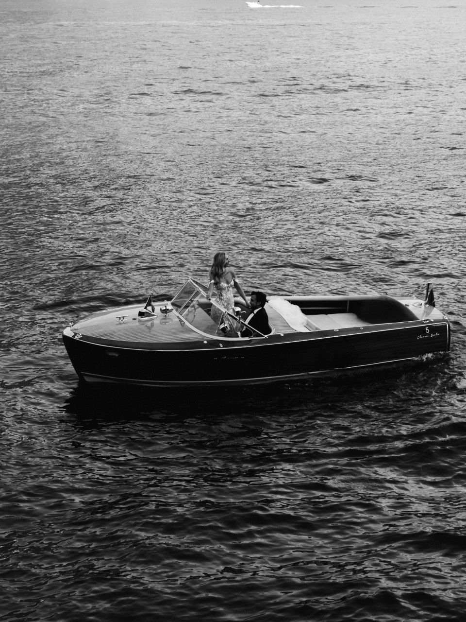 een zwart-wit foto van een man in een speedboot