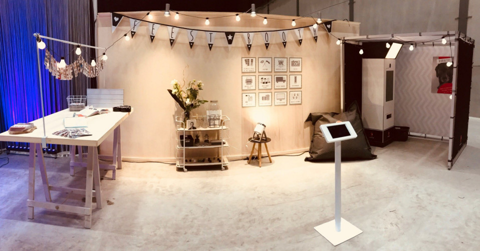 een fotocabine met een tafel en een witte muur