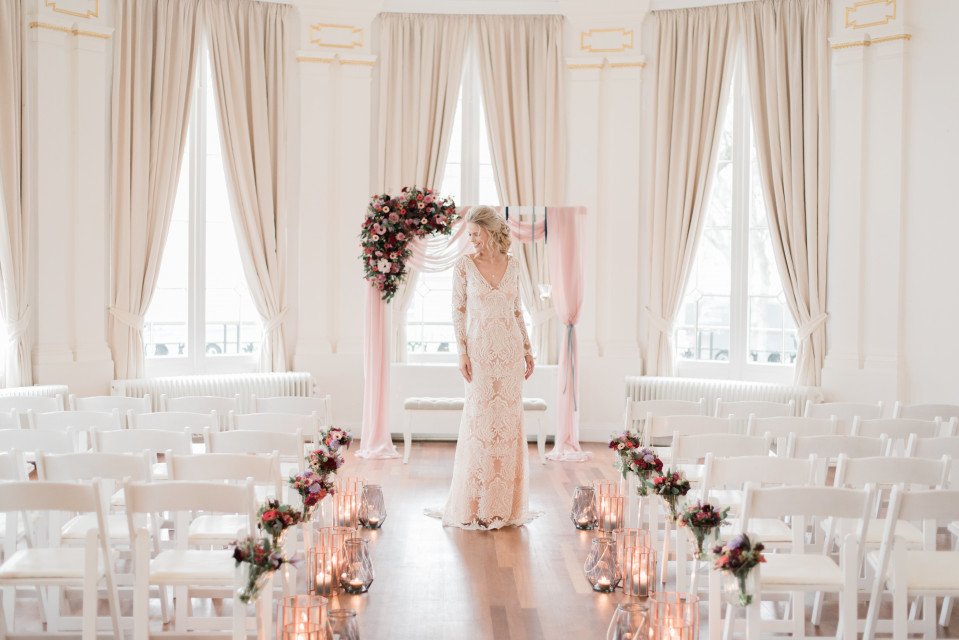 een bruid die staat voor een witte kamer met witte stoelen
