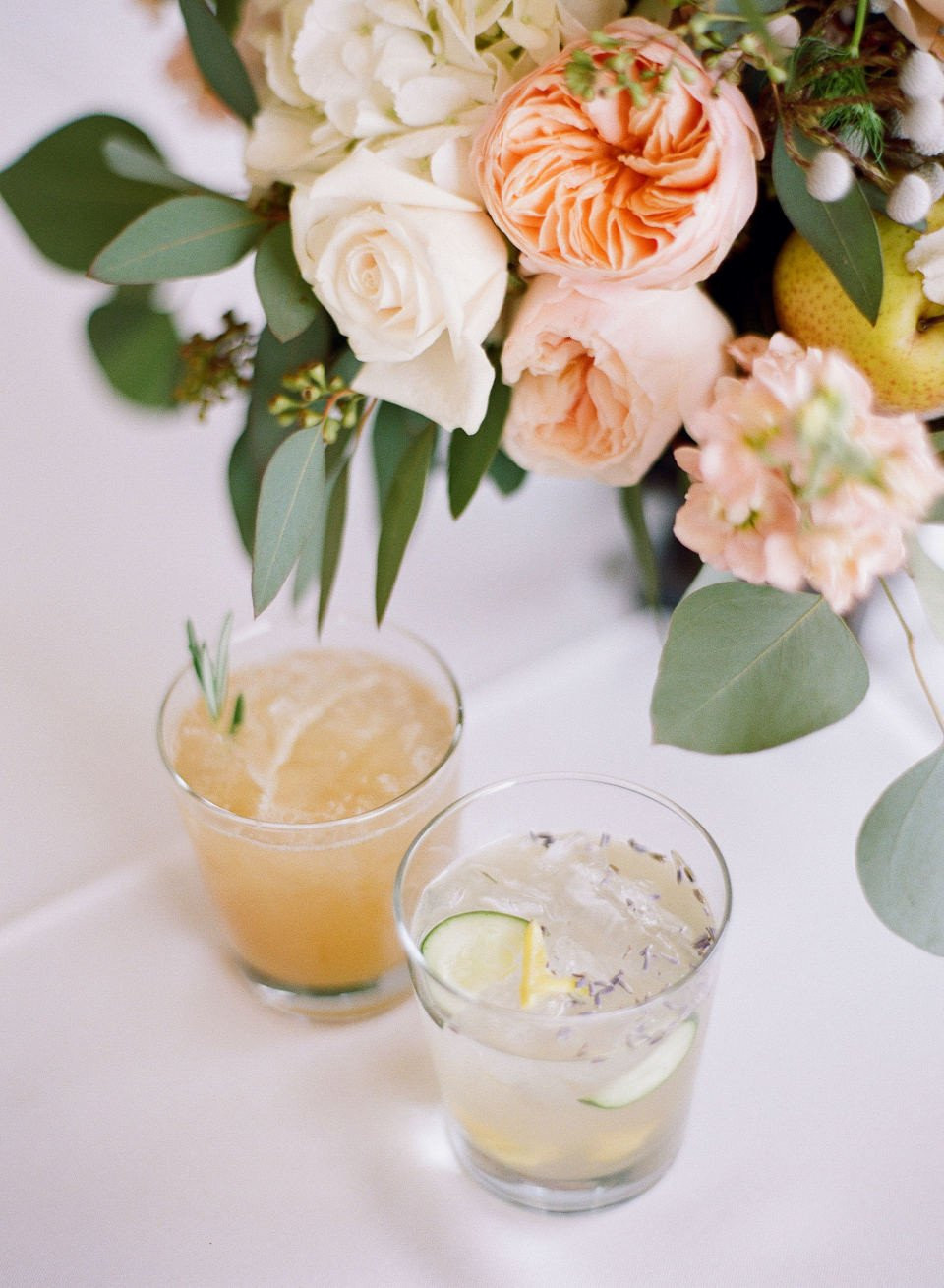 twee glazen cocktails met bloemen en fruit