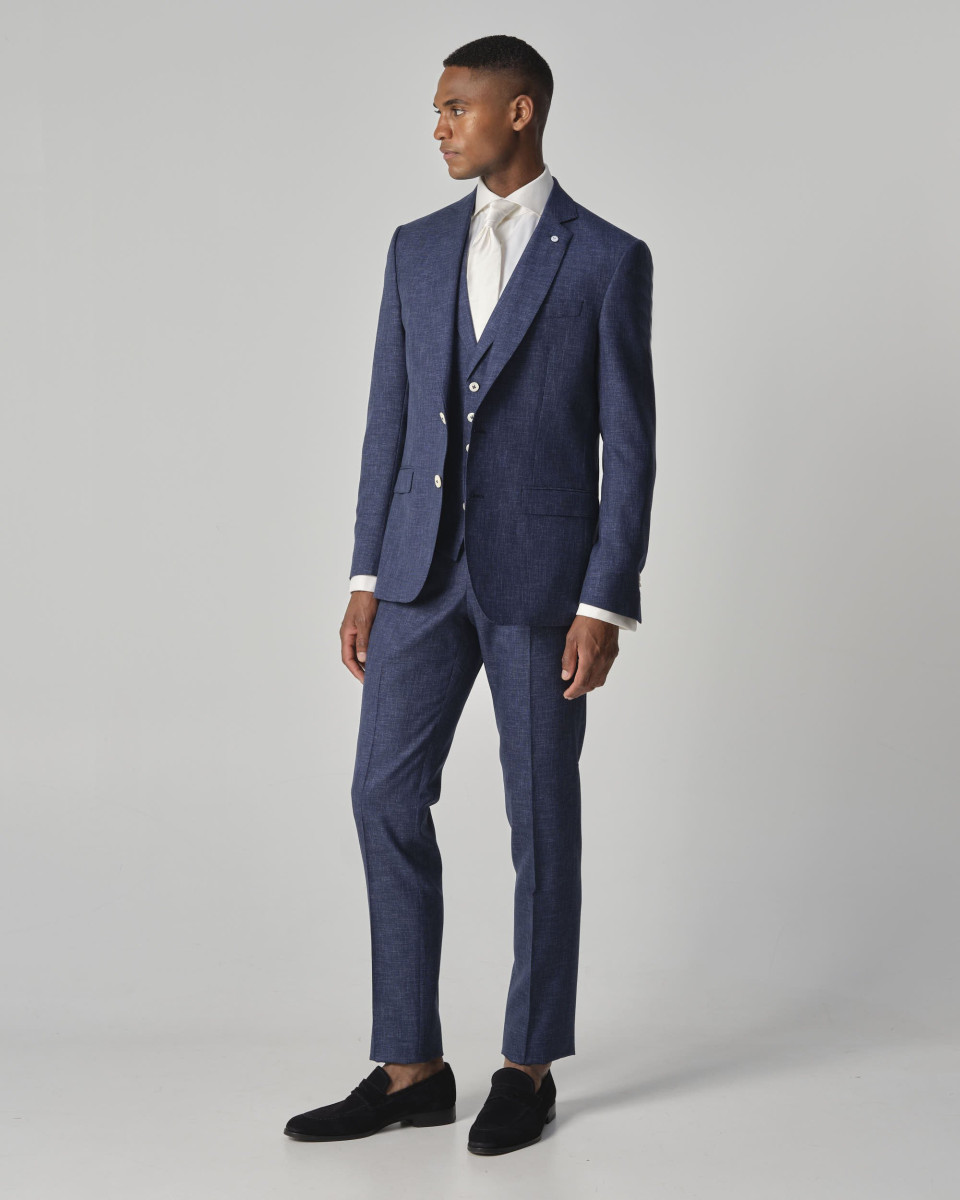 het model draagt een blauw pak en een wit shirt