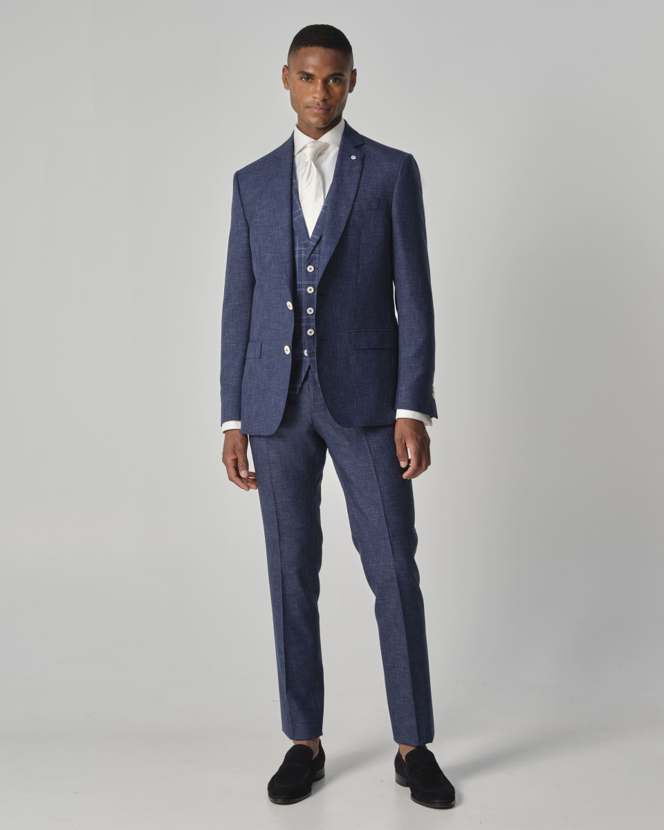 het model draagt een blauw pak en een wit shirt