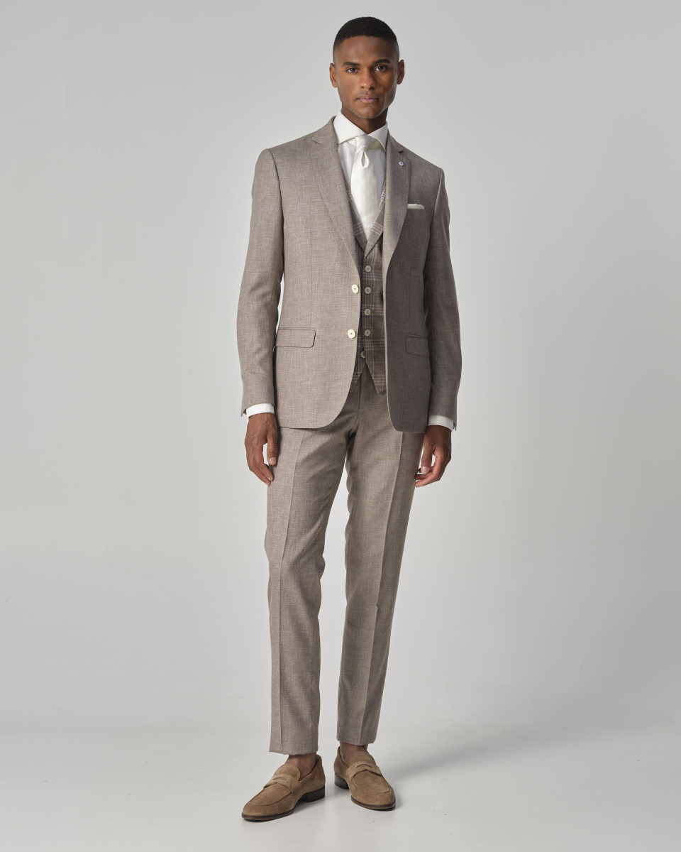 een man in een beige pak en schoenen