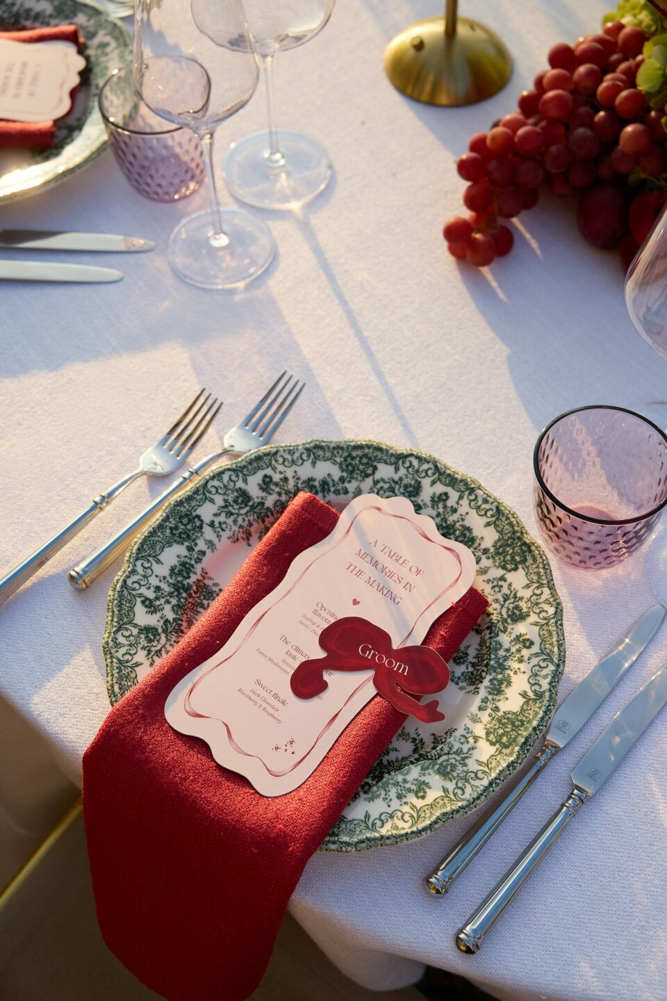 een tafelsetting met een rode servet en wijnglazen