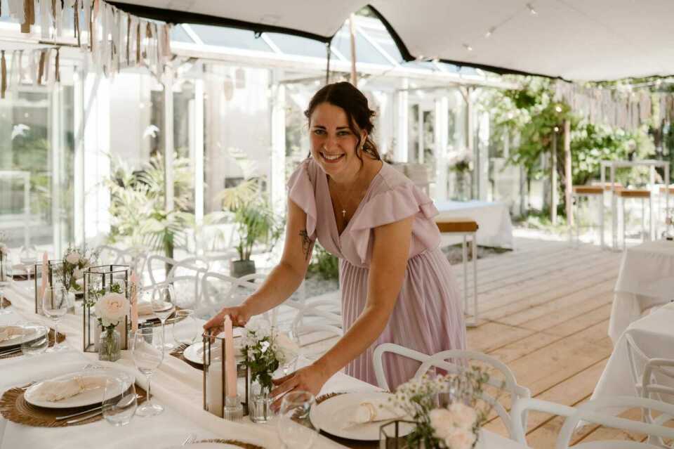 een afbeelding van een vrouw die een tafel dekt