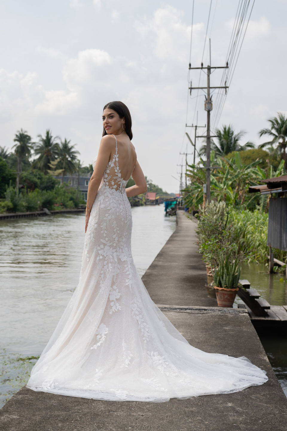 een vrouw in een trouwjurk die op een steiger staat