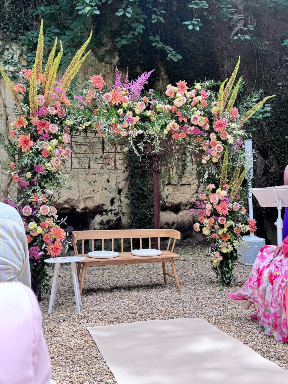 een bruiloftsceremonie met een bloemenboog