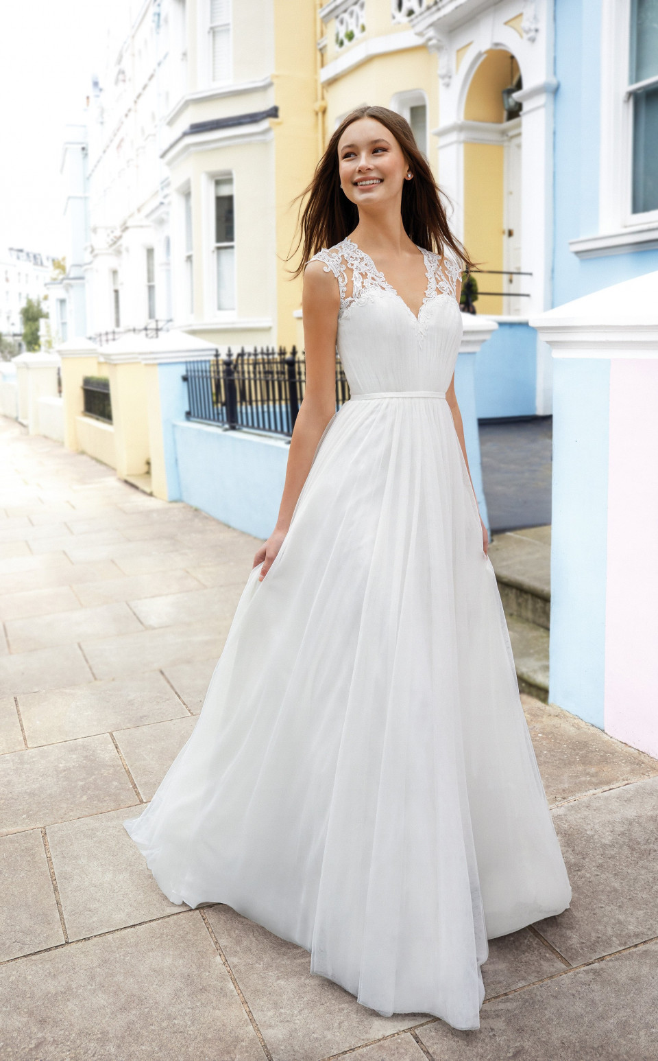 een vrouw in een witte trouwjurk die op een stoep staat