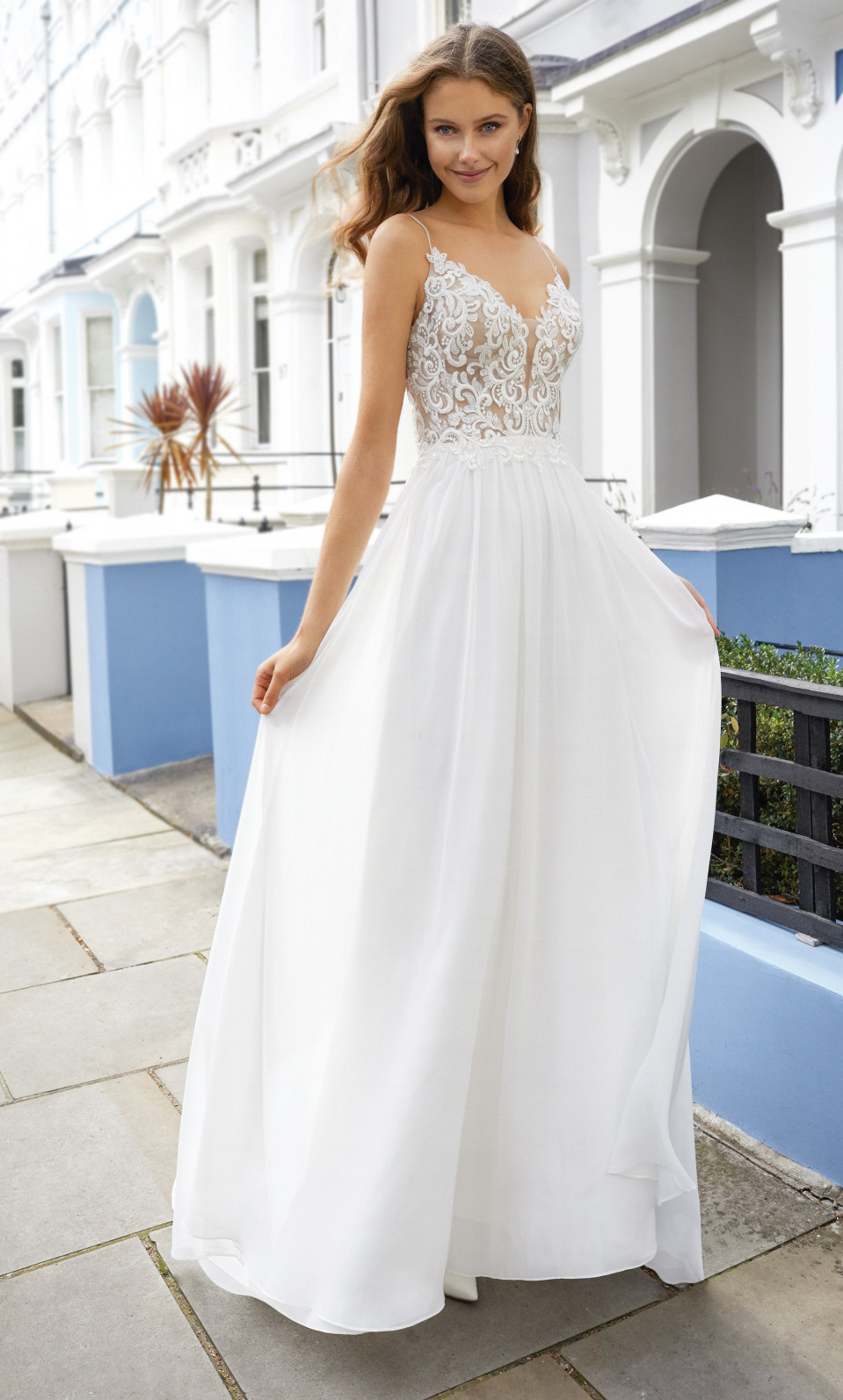 een mooie vrouw in een witte trouwjurk die op straat staat