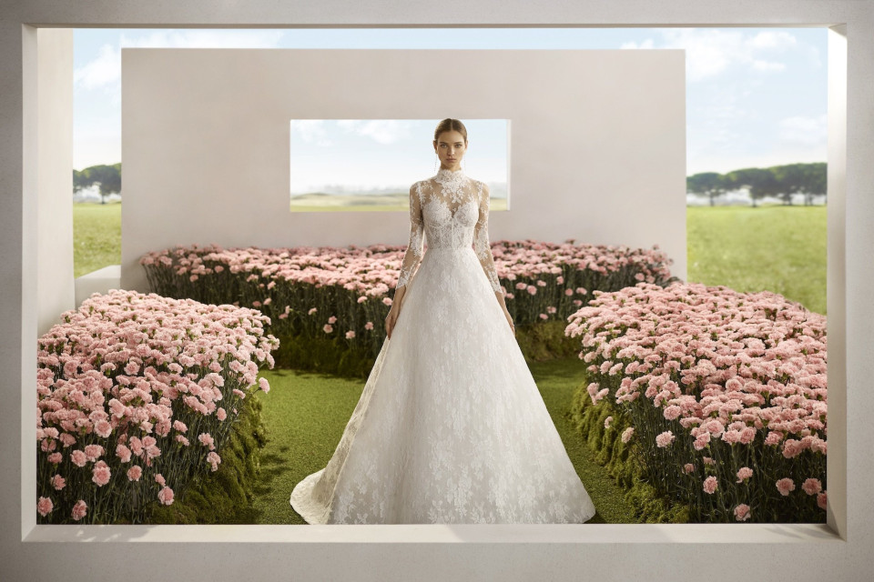 een vrouw in een trouwjurk die in een veld met bloemen staat