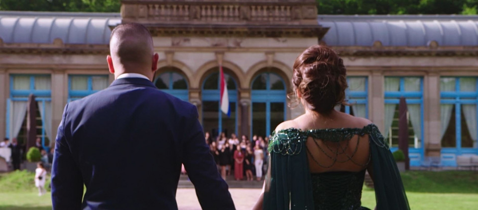 een man en vrouw in formele kledij die samen lopen