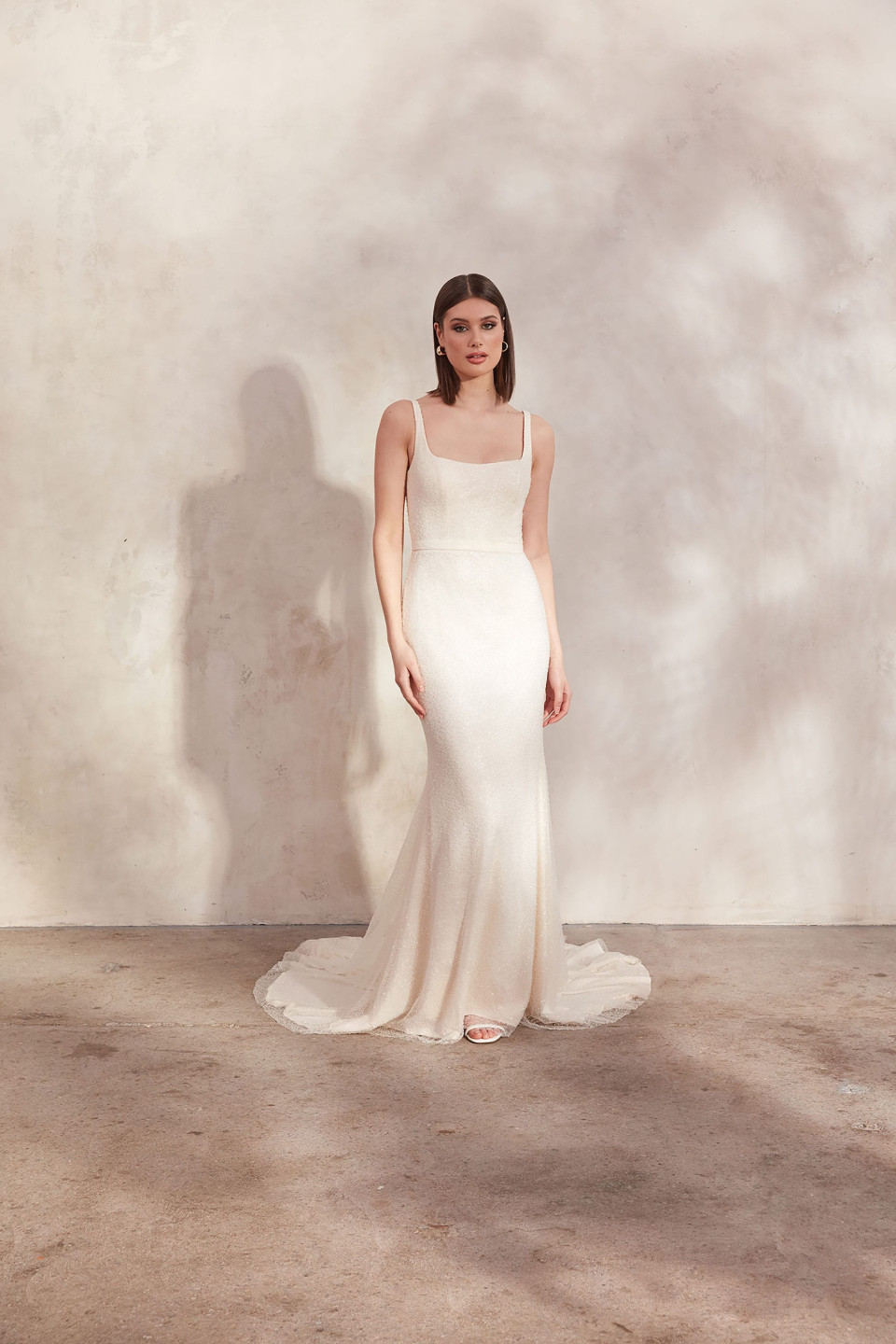 het model draagt een witte trouwjurk met een lage rug