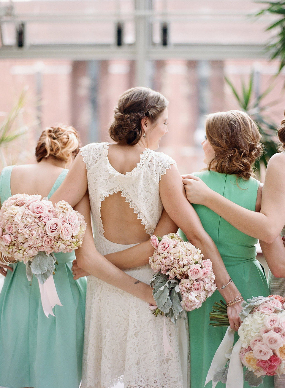 bruidsmeisjes in mintgroene jurken met roze en witte bloemen