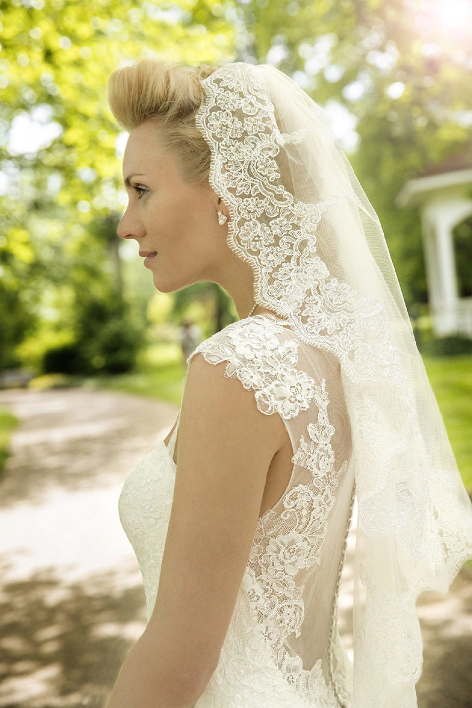 een mooie blonde vrouw in een trouwjurk en sluier