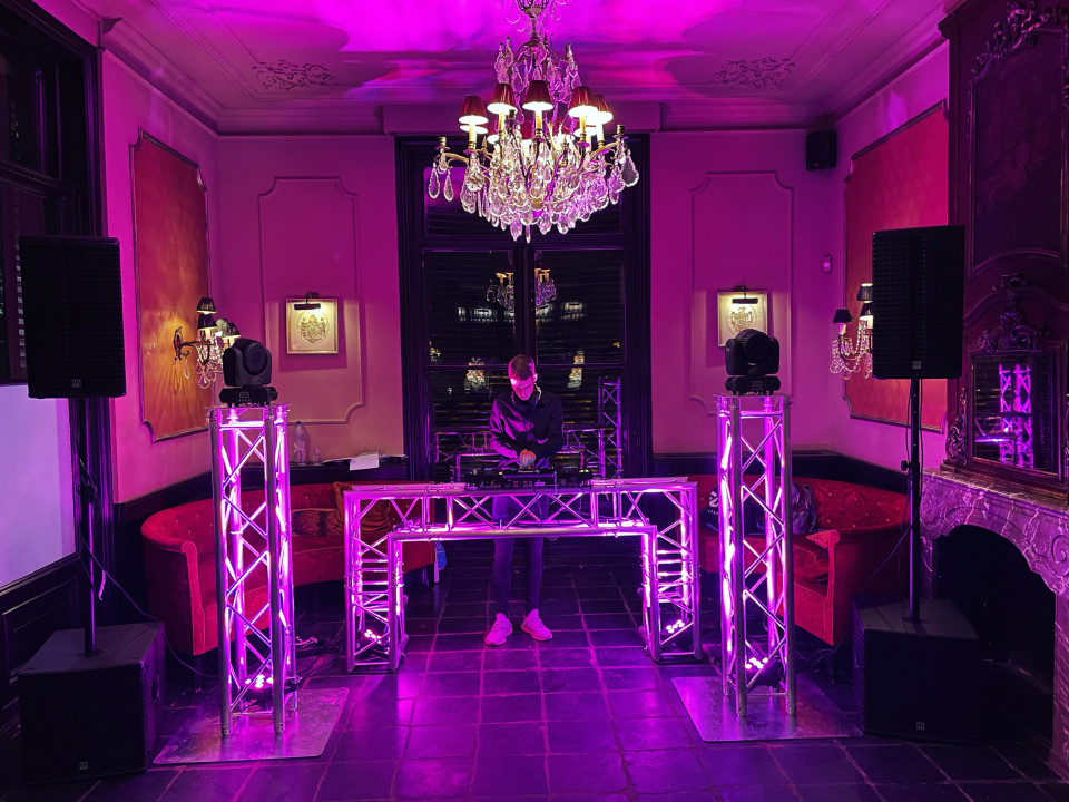 een kamer met paarse verlichting en een dj-set