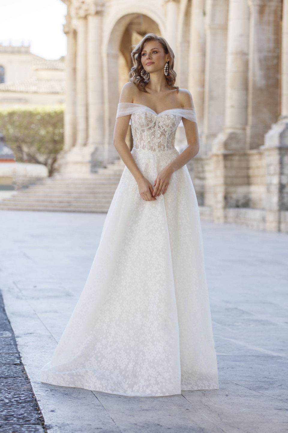 de trouwjurk is een mooie witte jurk met een kanten lijfje en off-shoulder