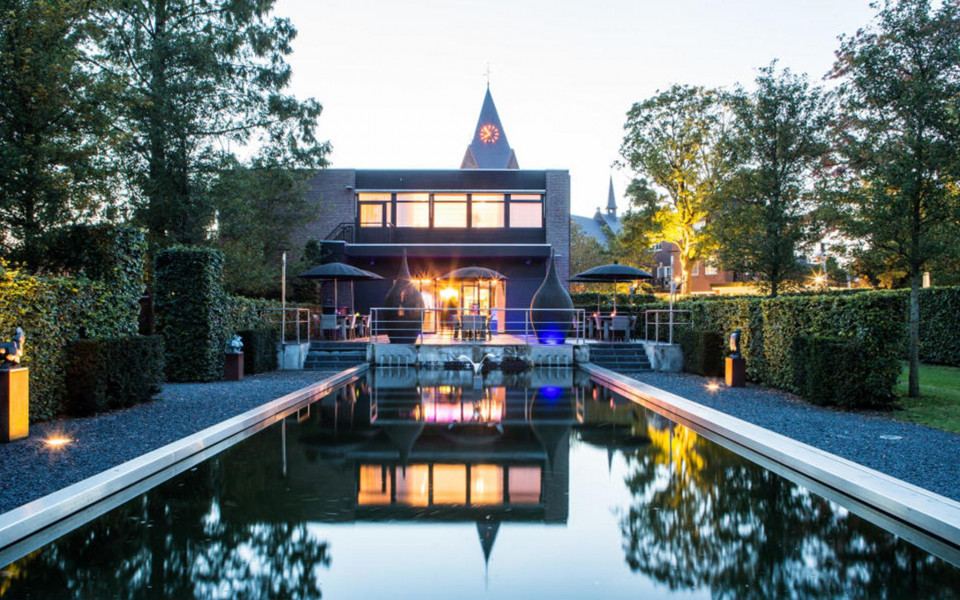 een huis met een zwembad en een kerk op de achtergrond