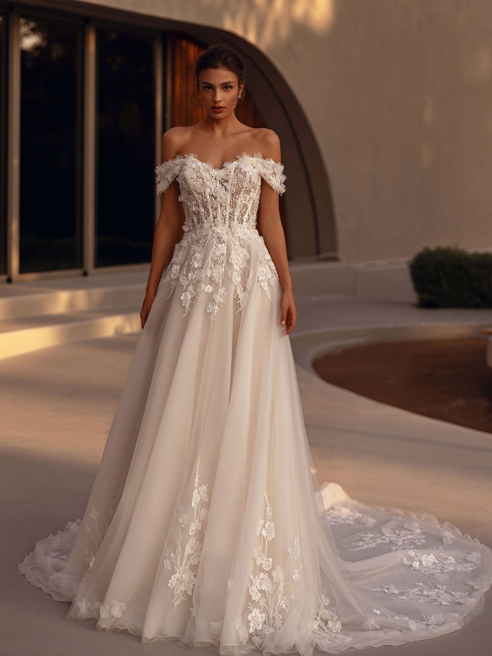 een vrouw in een trouwjurk die voor een gebouw staat