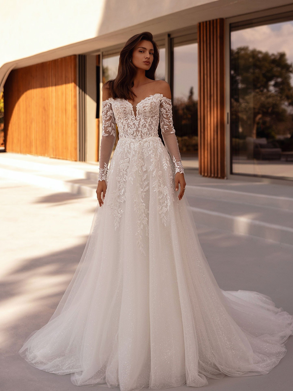 een vrouw in een trouwjurk die voor een gebouw staat