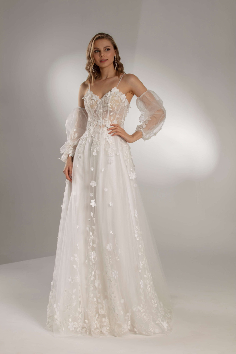 de trouwjurk is gemaakt van tule en kant