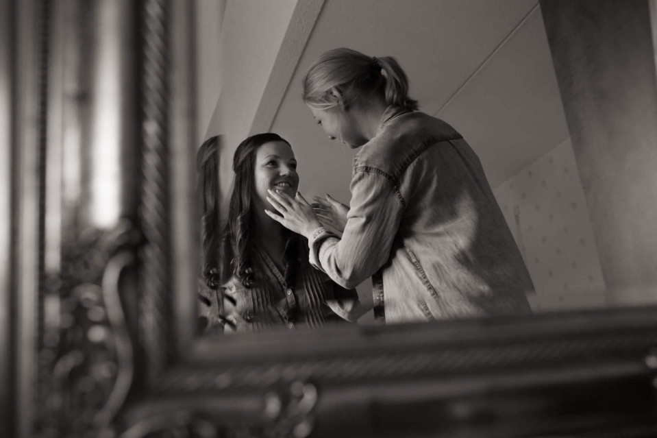 een vrouw die haar trouwring om doet voor een spiegel
