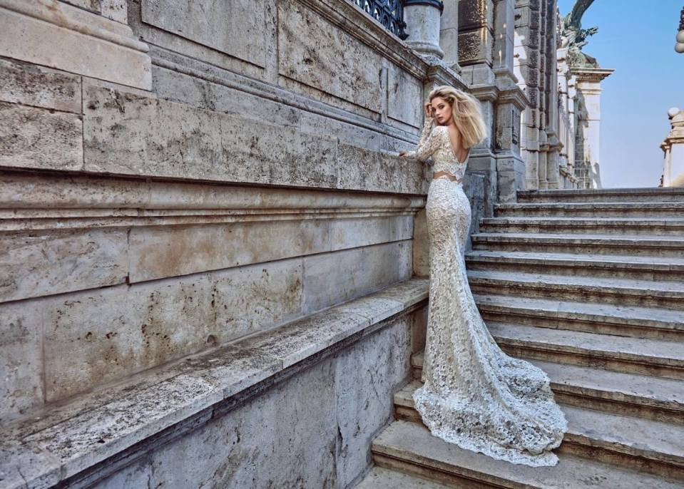 een mooie blonde vrouw in een trouwjurk staande op de trappen