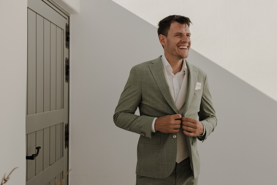 een man in een groene suit die glimlacht