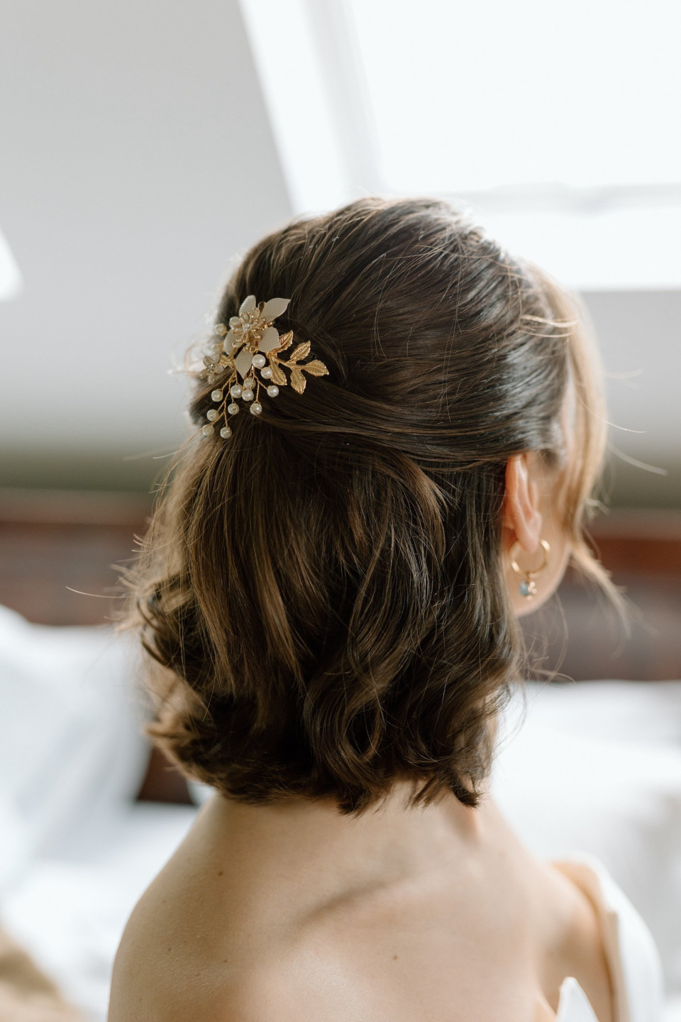 een bruid met haar haar in een knot en een gouden haar kam