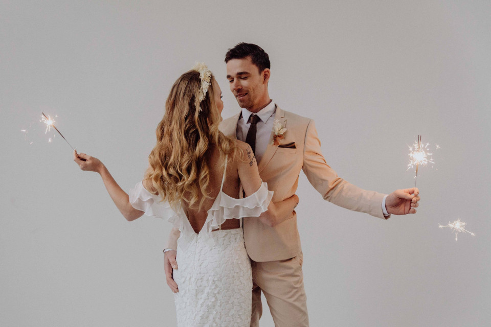 een bruid en bruidegom houden sterretjes vast