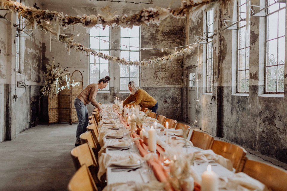 een stel dat een tafel opzet in een oud gebouw