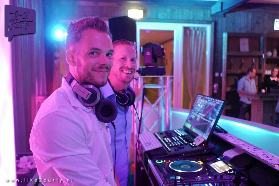 twee mannen in witte overhemden en koptelefoons op een feest