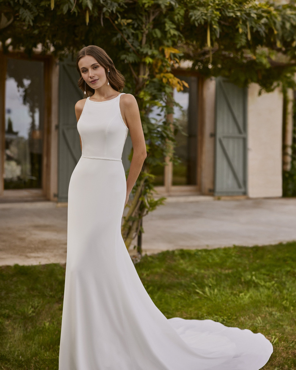 een vrouw in een witte jurk poseert voor een foto