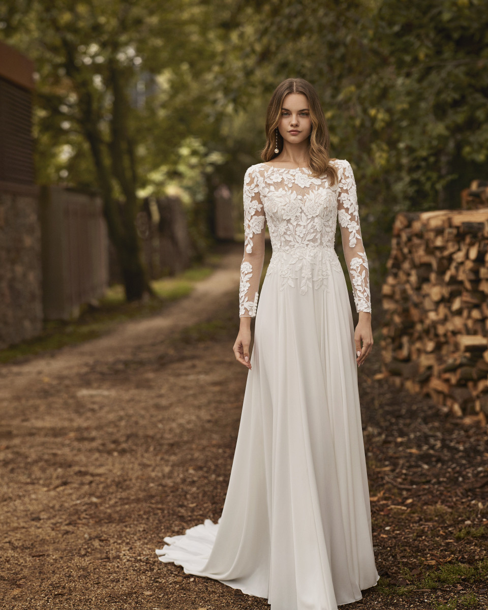 een vrouw in een trouwjurk staande op een onverharde weg