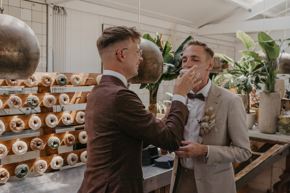 twee mannen in pakken voeren elkaar donuts