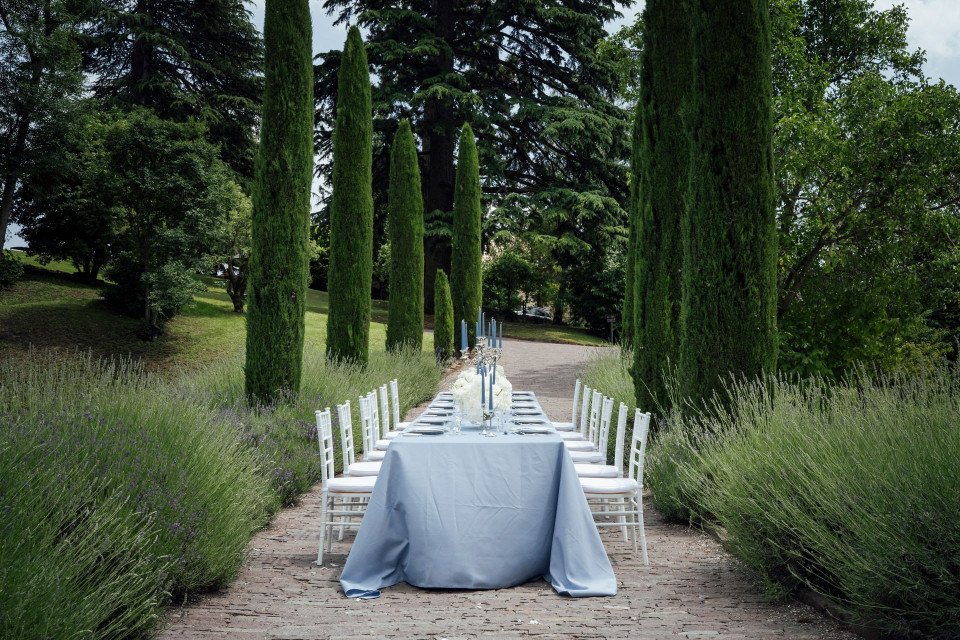 een lange tafel opgesteld in het midden van een tuin