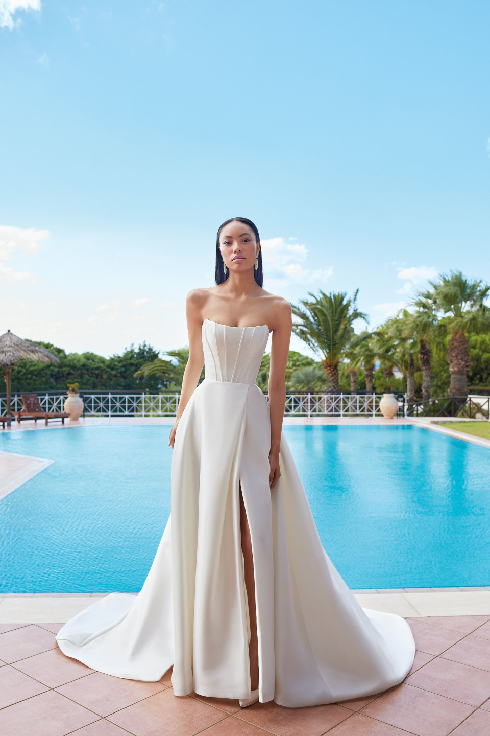 Deze elegante trouwjurk heeft een modern en verfijnd ontwerp, ideaal voor een bruid met een zandloperfiguur, en zou perfect gedragen worden op een luxe buitenlocatie of chique binnenlocatie