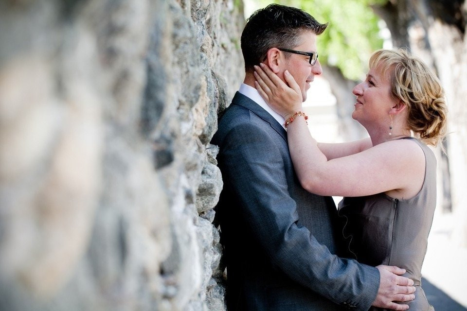 een man en vrouw omhelzen elkaar voor een stenen muur