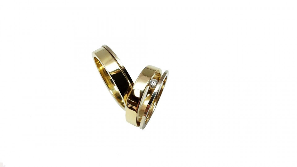 twee gouden trouwringen op een witte achtergrond