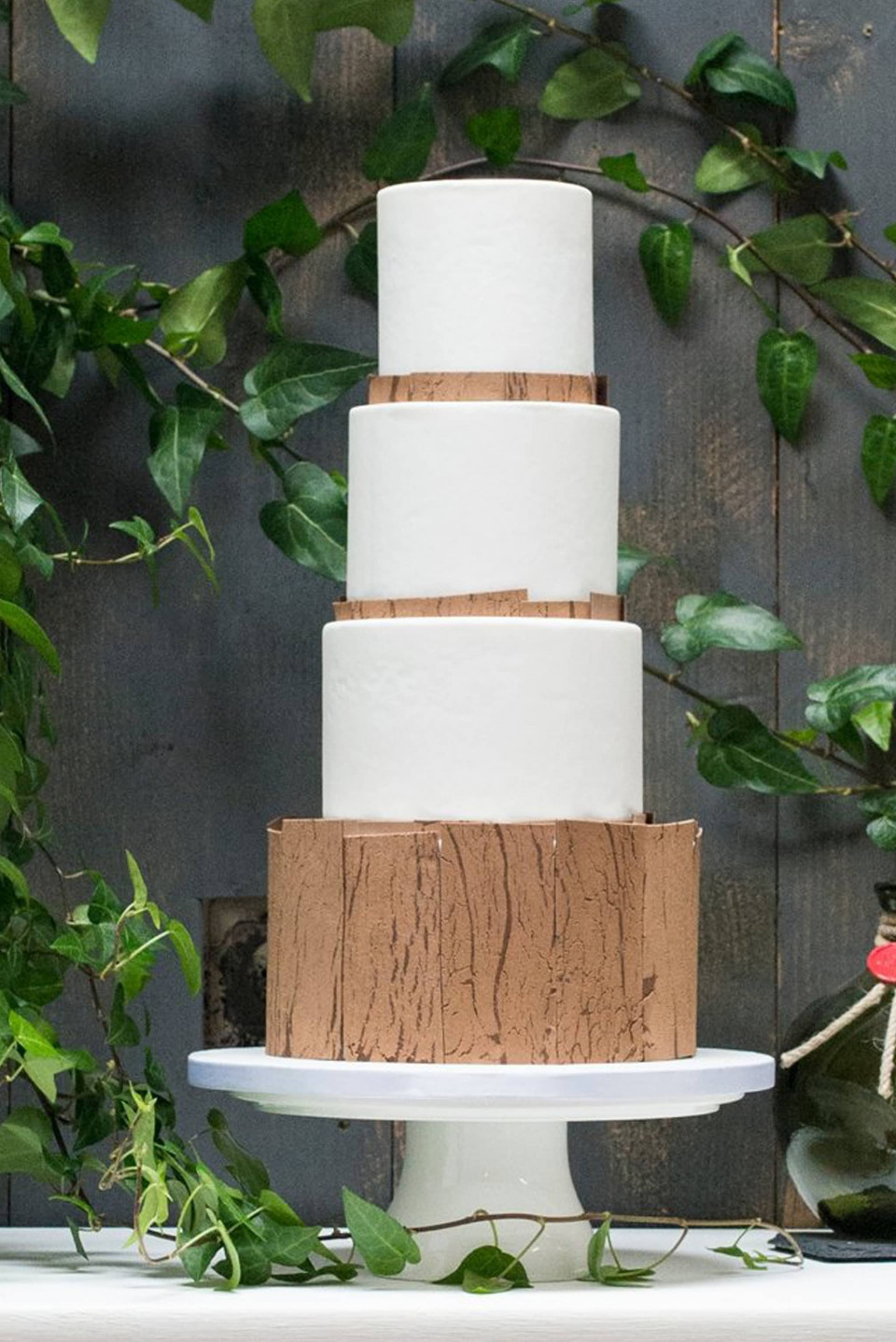 een trouwtaart met een houten basis en witte glazuur