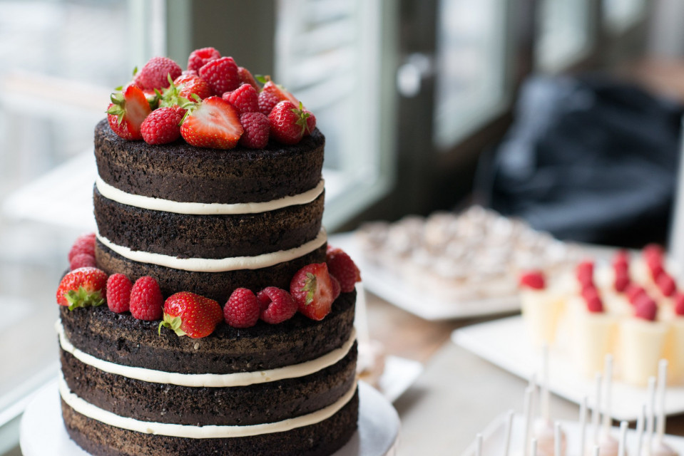 een chocoladetaart met aardbeien en room erop