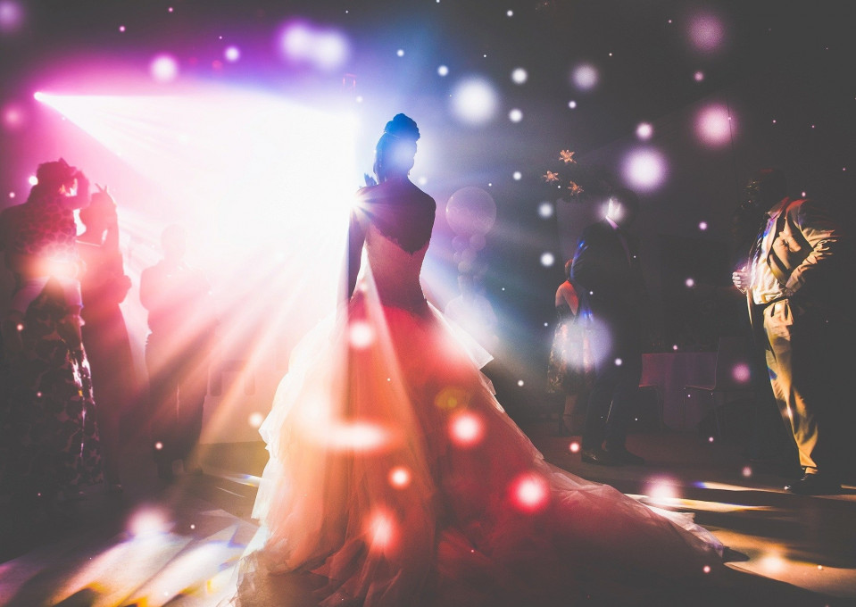 een bruid en bruidegom die dansen voor een discolicht