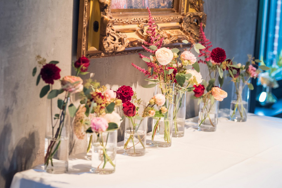 bloemen in vazen op een tafel voor een schilderij