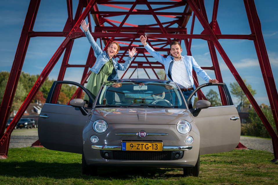 twee mensen in een auto met hun handen omhoog