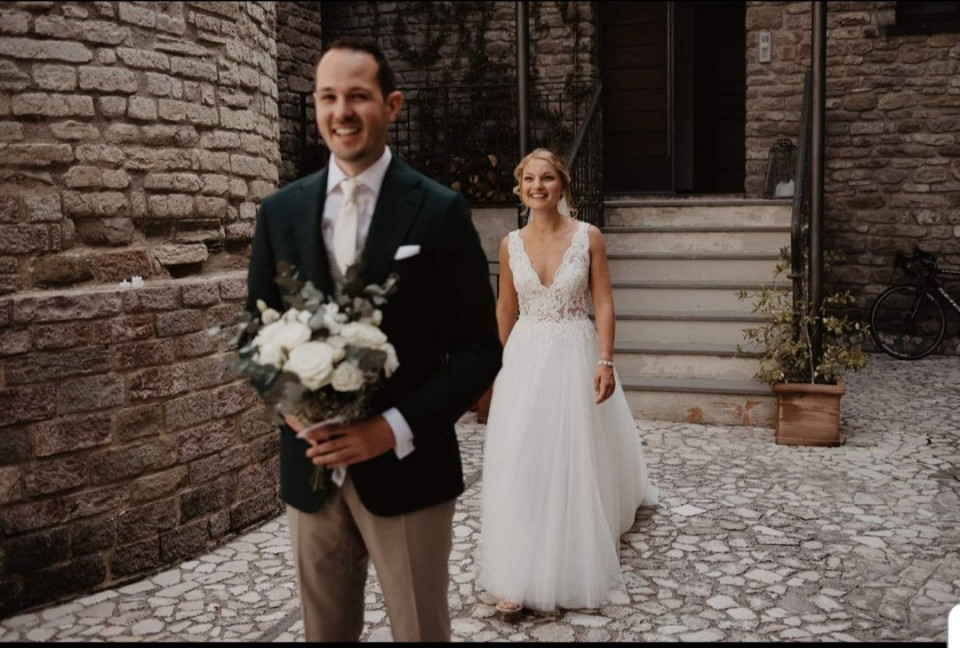 een bruid en bruidegom die langs een stenen pad lopen