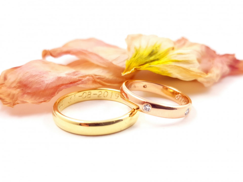 twee trouwringen met bloemen op een witte achtergrond