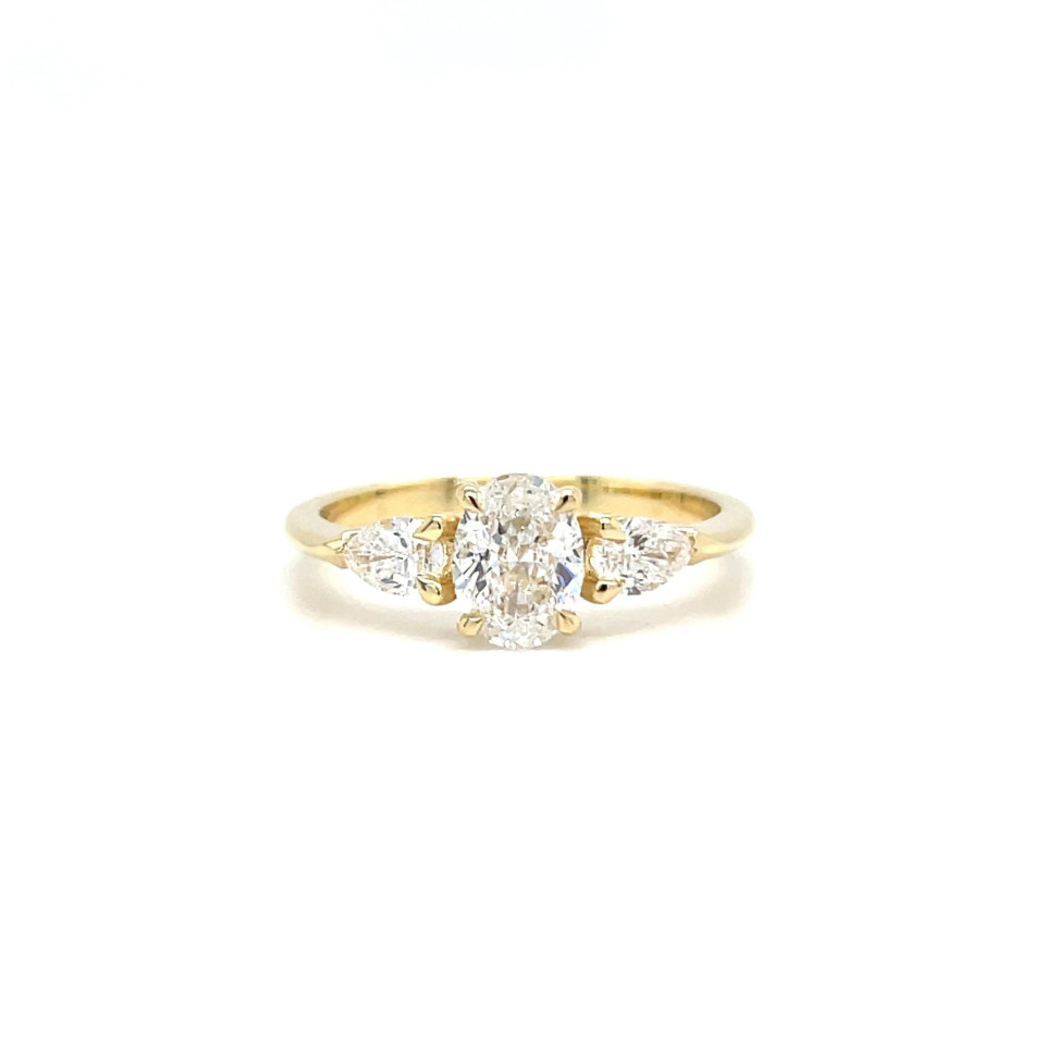 een ovale diamanten ring met drie stenen in geelgoud