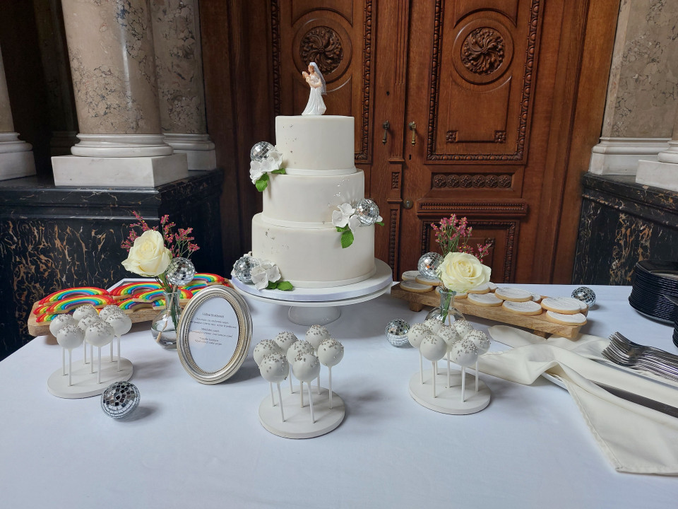een bruidstaart op een tafel met een paar snoepjes