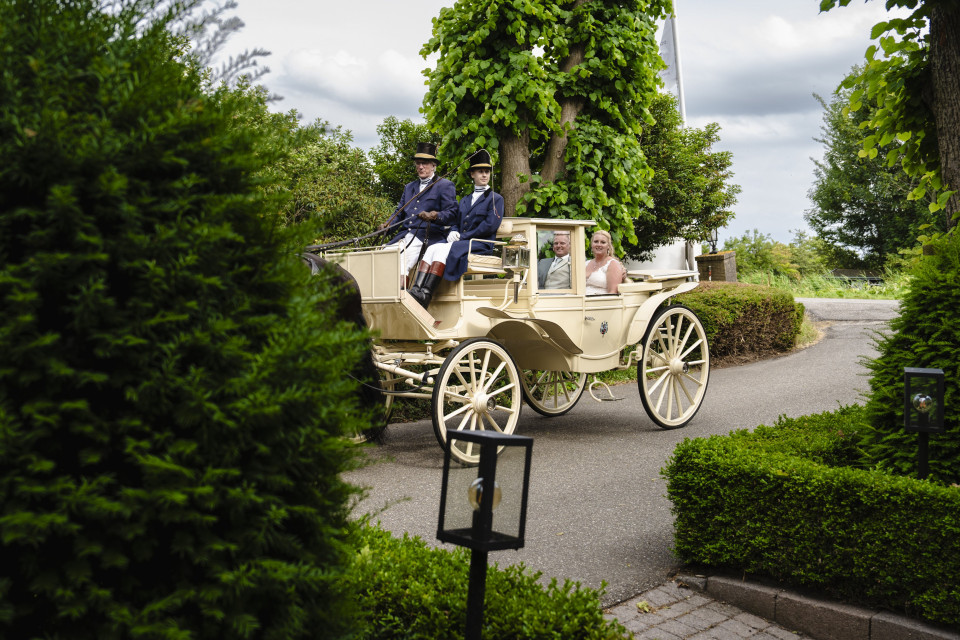 een stel rijdt in een met paarden getrokken koets